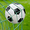 Close-up of a soccer ball flying into the net