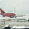 Airport terminal under winter snowfall.