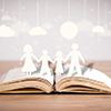 Open book with cardboard cutout of family - story concept