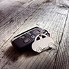 Car shape keyring and keyless entry remote on wood background