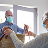 Groceries delivery to senior citizens with face mask in home quarantine for Covid-19 coronavirus