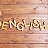 Word english made with block wooden letters next to a pile of other letters over the wooden board su