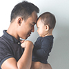 A portrait of a Young Asian father holding his adorable baby on white background