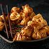 Chinese takeaway finger food Vegetable wontons with sweet chilli dip sauce and chop sticks.