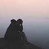 alone man sitting with sadness emotion on wood pier