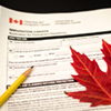 Canada immigration form with pencil and maple leaf