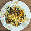 kabuli palaw rice dish on white patterned plate on wooden counter