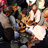 Group of people eating sweets in celebration of Makar Sankranti festival in India.