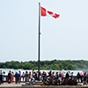 canada flag and group of people standing at Niagara falls