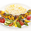 Grilled, marinated morsels of chicken without bones arranged on a plain white plate. Fusion food con