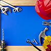 Tools and helmet on a blue background in a wooden frame