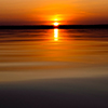 Water surface. View of a Sunset sky background. Dramatic gold sunset sky with evening sky clouds ove