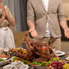 Homemade roasted turkey among fresh fruits, salad and desserts on served table