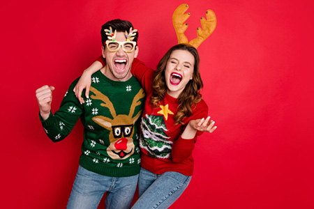 Happy couple wearing holiday sweaters