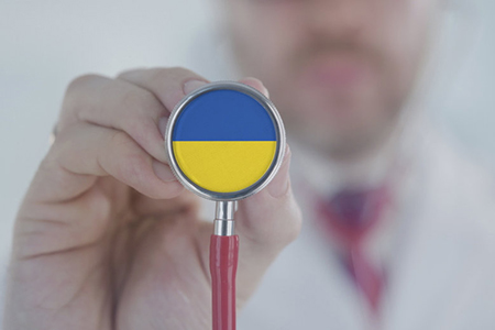 Doctor listening with the stethoscope with flag of Ukraine. Ukrainian healthcare