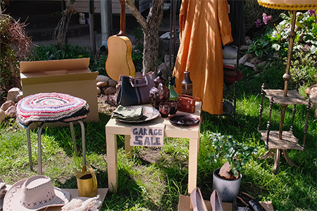Used items and clothes for garage sale in front yard