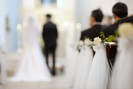 blurred image of bride and groom at alter