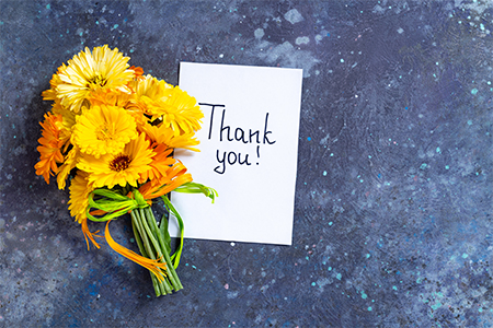 Notes thank you with bouquet of yellow flowers calendula on blue background