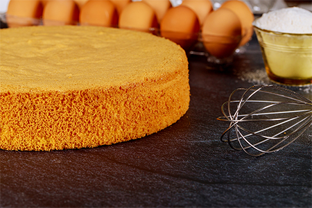 Soft sponge cake with ingredients: brown eggs, flour and whisk