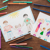color pencils and felt pens, and white papers with drawings of family