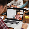 Rear view of university student understanding concepts online while making notes