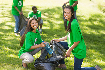 A vibrant community clean-up day brings together volunteers clad in green shirts, joyfully collectin