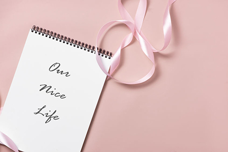 top view on notebook with article title - pink ribbon on table