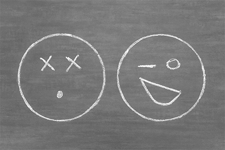 emoticons drawn in white chalk on a gray board