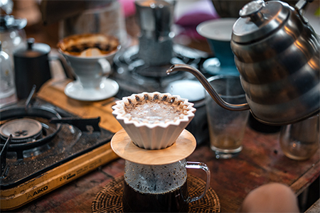 Drip coffee, barista pouring water on coffee ground with filter