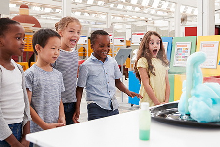 Kids having fun watching an experiment at a science centre