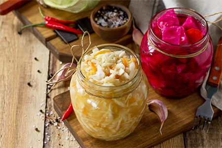 Homemade Sauerkraut with Carrot and Salad Cabbage with Beetroot on a wooden table
