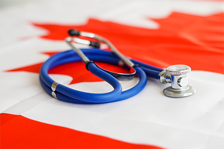 Medical stethoscope on a Canada flag. Canadian health care system