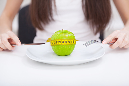 tape measure coiled around an apple on white plate