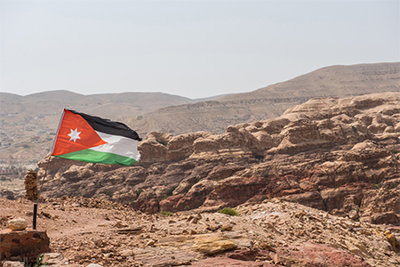 The flag of Jordan blowing in the wind in Petra, Jordan