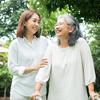 a young woman and elderly grandmother enjoy a sunny day in a lush garden