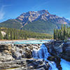The Athabasca Falls with Rocky Mountain peak behind