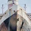A large old rusty industrial ship under the sunlight and a blue sky