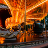 Night view of brightly illuminated merry go round carousel in amusement park, close up