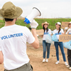 Volunteers from the youth community using rubbish bags cleaning up nature