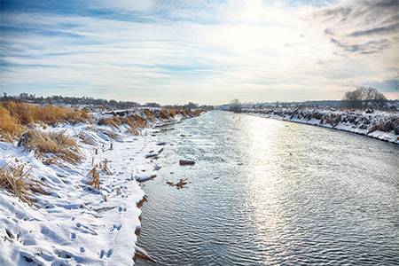 Winter landscape by a river during sunset