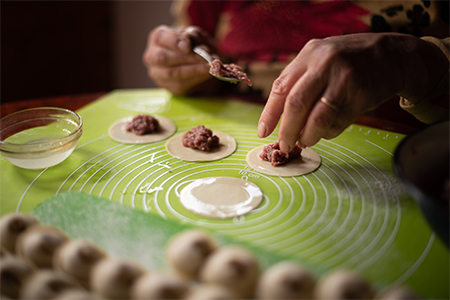 woman preparing dumplings in the kitchen