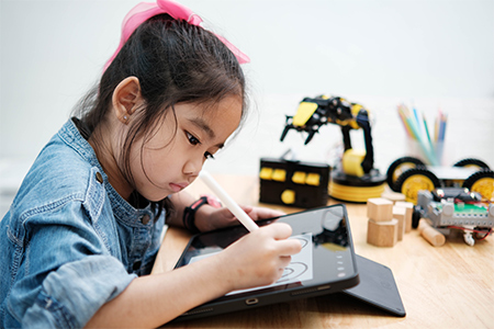 A primary school girl focuses on learning using tablet