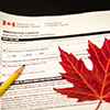 canada immigration form with pencil and maple leaf