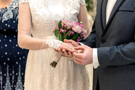 Groom and bride with beautiful ring and bouquet