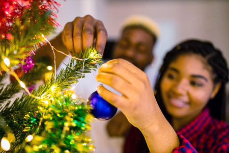family decorating Christmas tree with ball