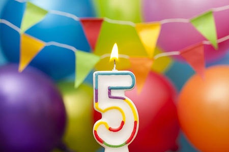 Happy Birthday number 5 celebration candle with colorful balloons and bunting