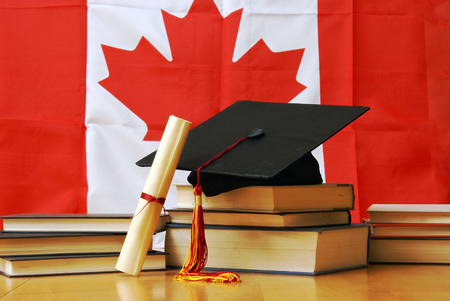 textbooks, graduation cap and diploma over canada flag