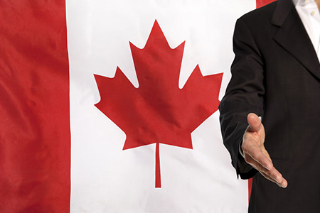 Businessman with an open hand waiting for a handshake concept for business with the Canada flag in t