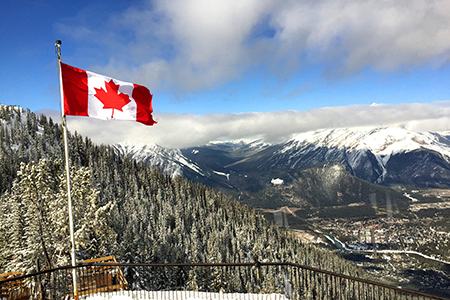 Canada flag overlooking winter mountain scene