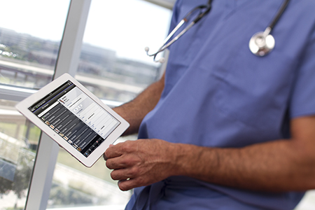man in scrubs holding tablet